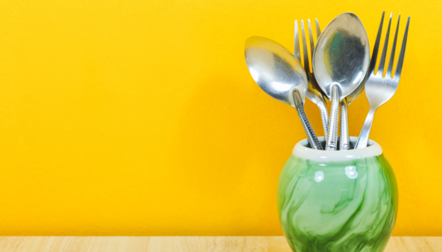 Fork and spoons on counter with orange backsplash