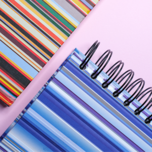 Striped notebooks on pink background
